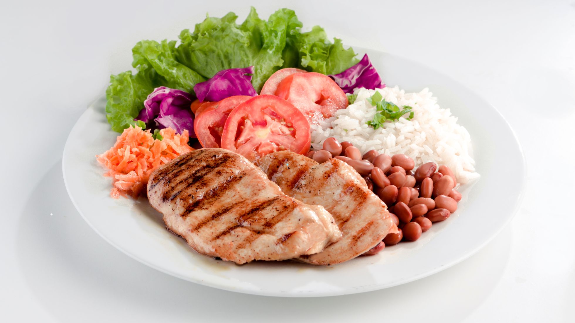 "Prato saudável com frango grelhado, arroz, feijão e salada fresca"